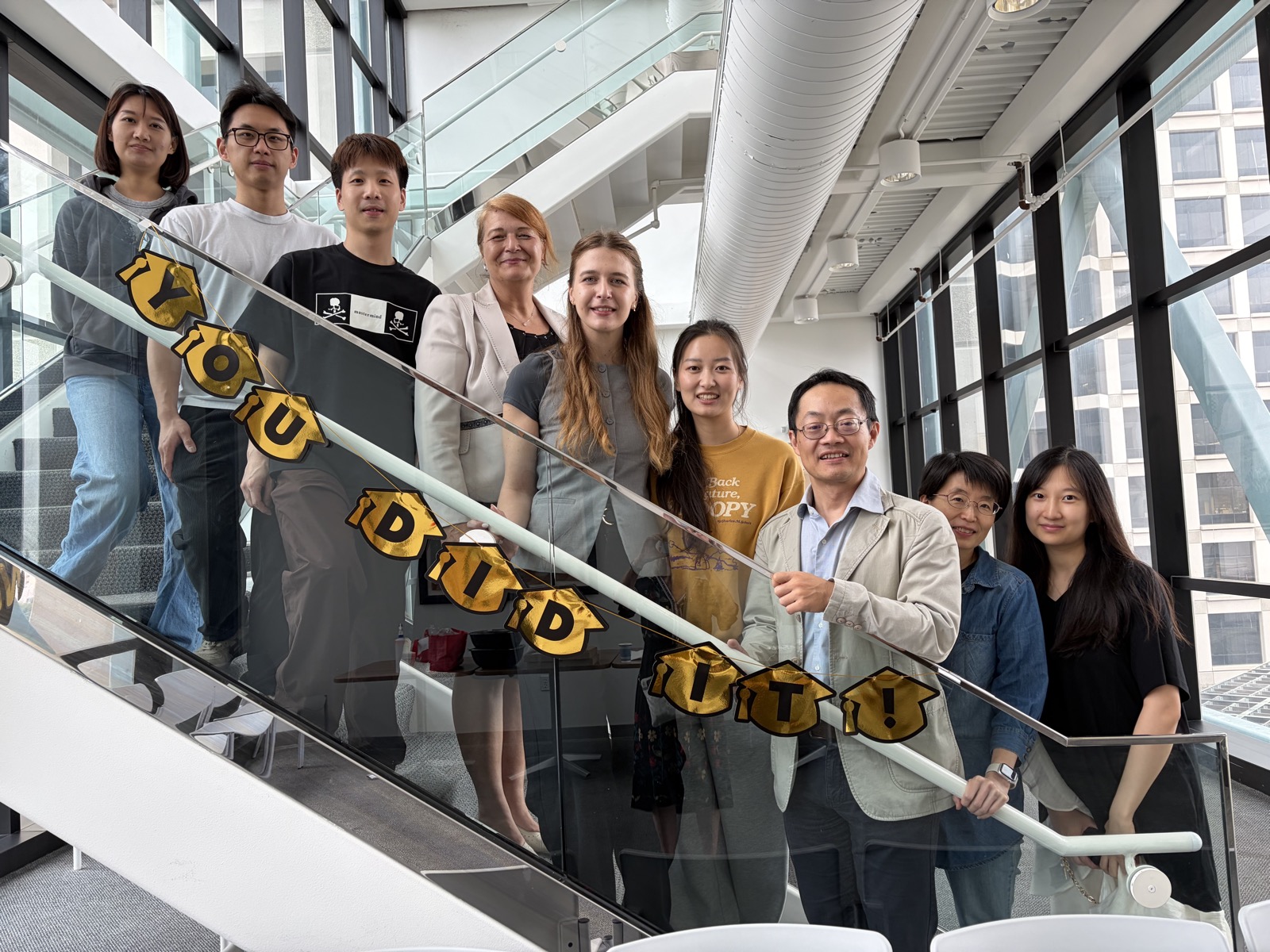 The Zhang Lab celebrating Emma's defense with a YOU DID IT banner