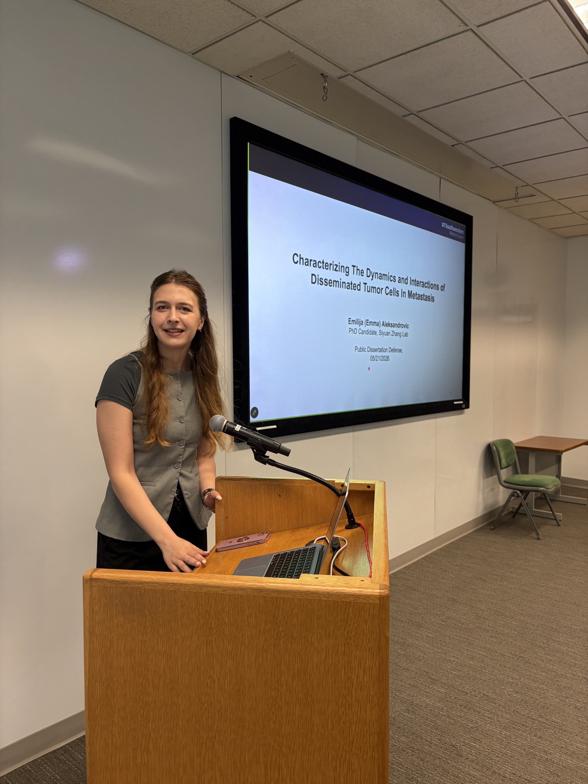 Emma Aleksandrovic presenting her public dissertation defense at the podium